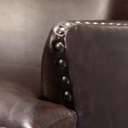 Poltrona a orecchioni Jorge in pelle vegana con borchie decorative per soggiorno e camera da letto