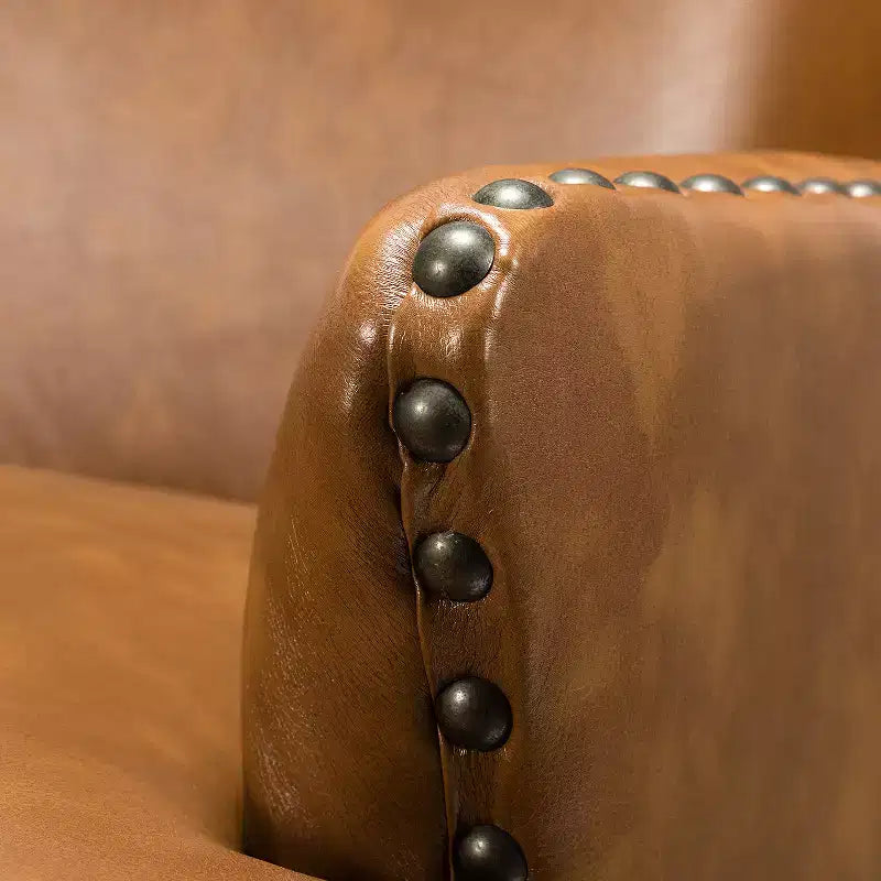 Poltrona a orecchioni Jorge in pelle vegana con borchie decorative per soggiorno e camera da letto